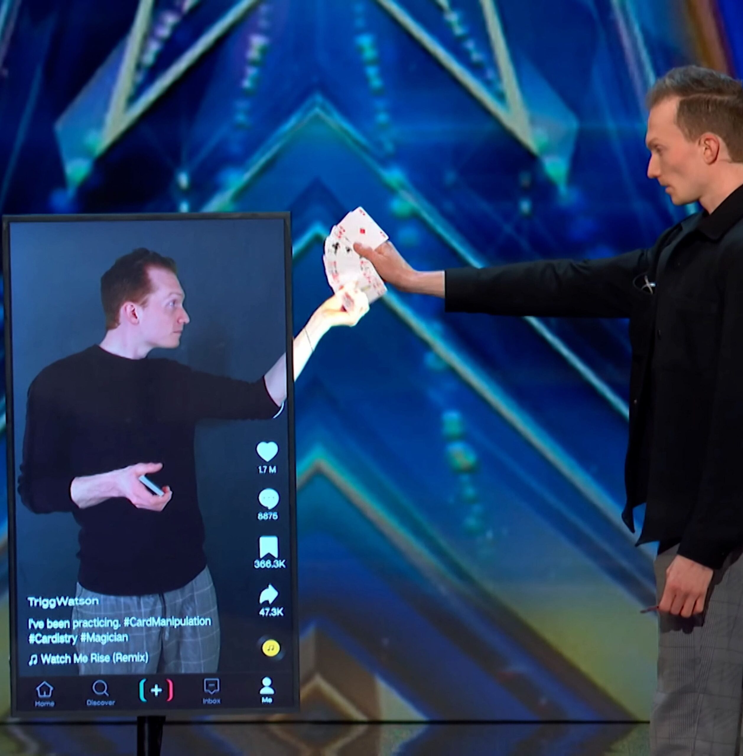 A holographic version of Trigg hands Trigg some cards through a TV screen.