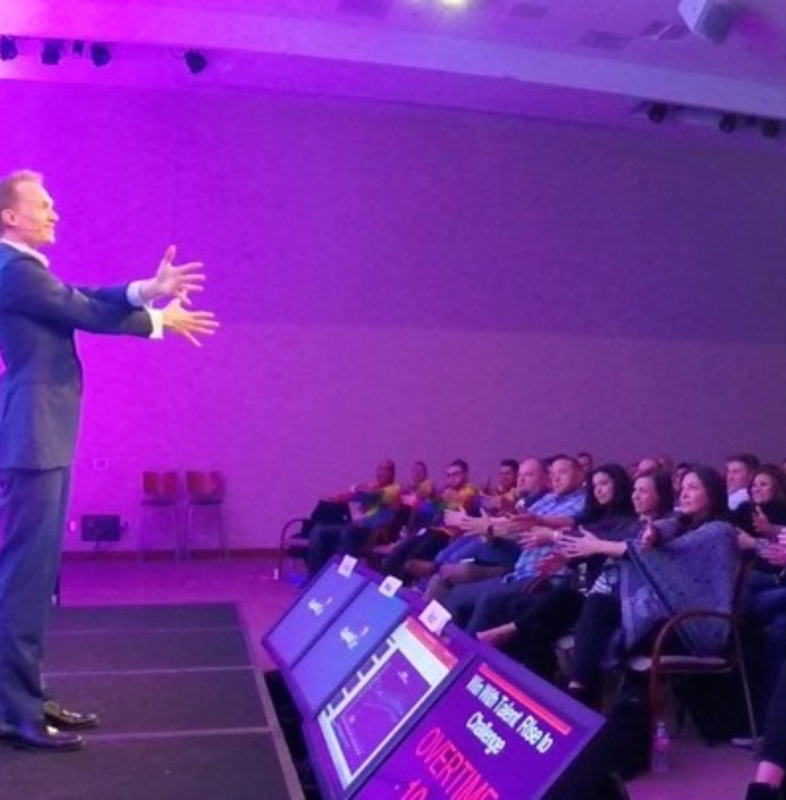 Trigg commands the stage of a corporate conference. 